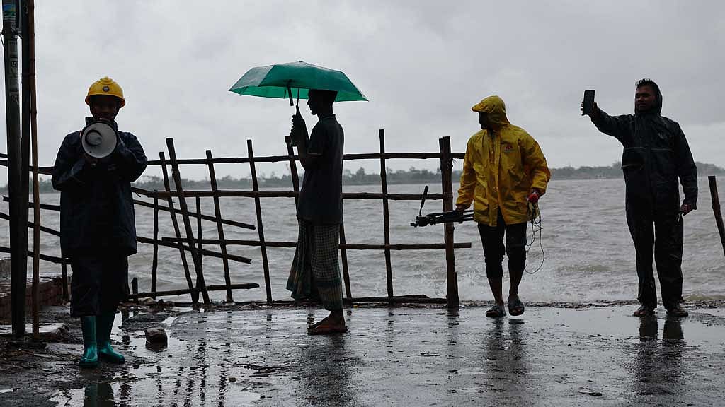 বাংলাদেশের সাতক্ষীরা জেলায় ঘূর্ণিঝড়ের মধ্যে লোকজনকে সতর্ক করছেন কয়েকজন স্বেচ্ছাসেবক। ছবি: রয়টার্স