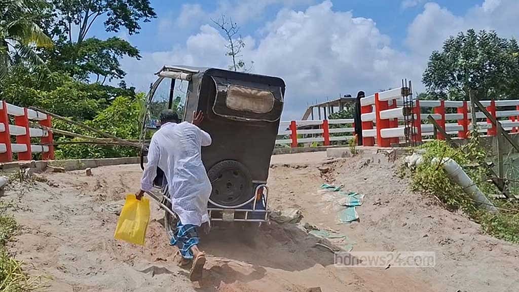 সংযোগ সড়ক না থাকায় ঝুঁকি নিয়ে ধাক্কা দিয়ে ব্রিজে অটোরিকশা ওঠাচ্ছেন যাত্রীরা। 