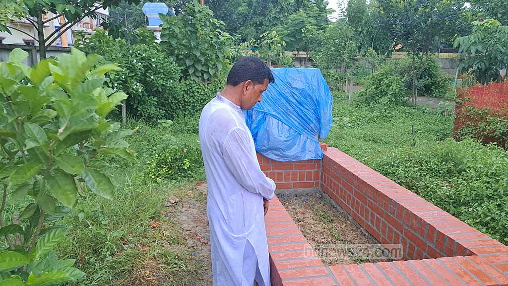 Nafisa’s father Abul Hossain standing silently before her grave.