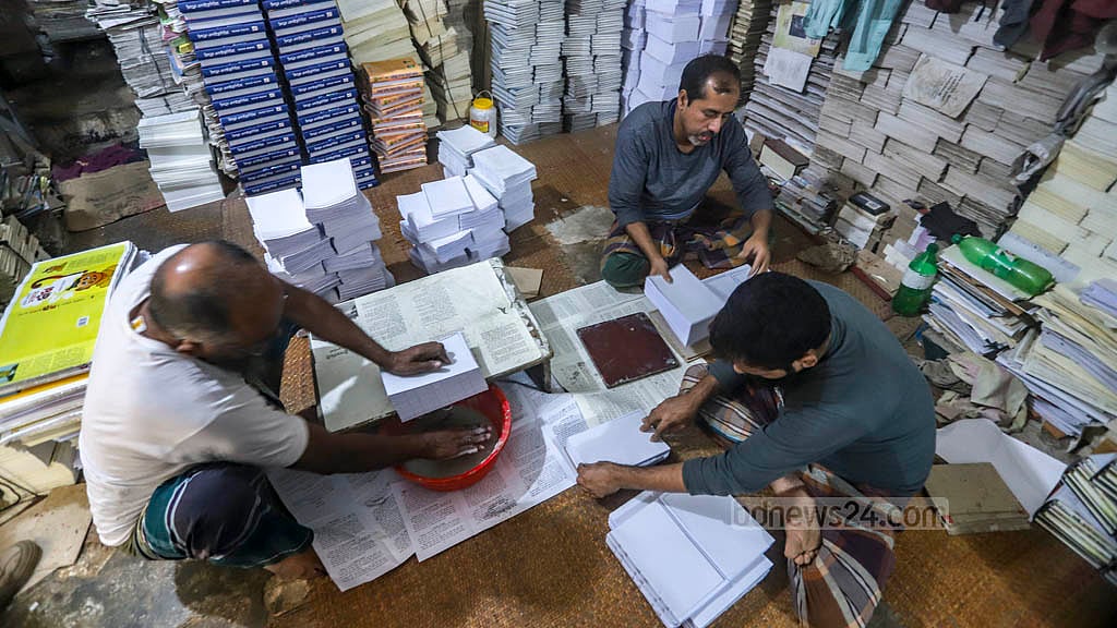 বই বাঁধাইয়ে ব্যস্ত কর্মী। ফাইল ছবি।