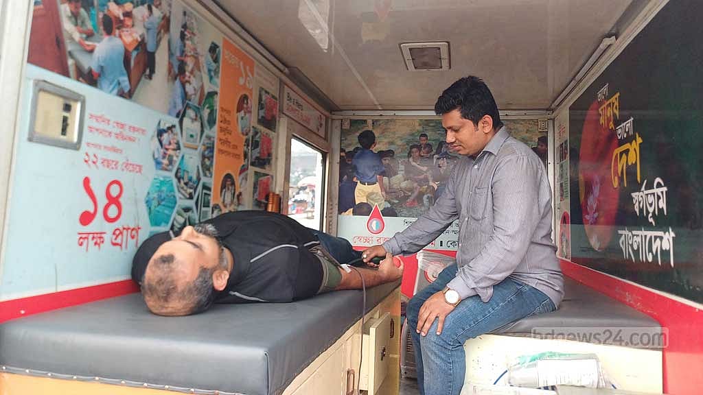 ভ্রাম্যমাণ রক্ত সংগ্রহ কেন্দ্রে রক্ত দিচ্ছেন একজন।