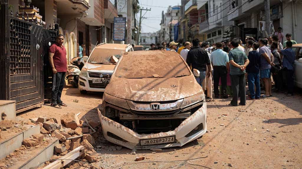 জম্মু শহরে পাকিস্তানি বাহিনীর হামলায় ক্ষতিগ্রস্ত গাড়ির পাশে দাঁড়িয়ে আছেন স্থানীয় বাসিন্দারা। ছবি: রয়টার্স 