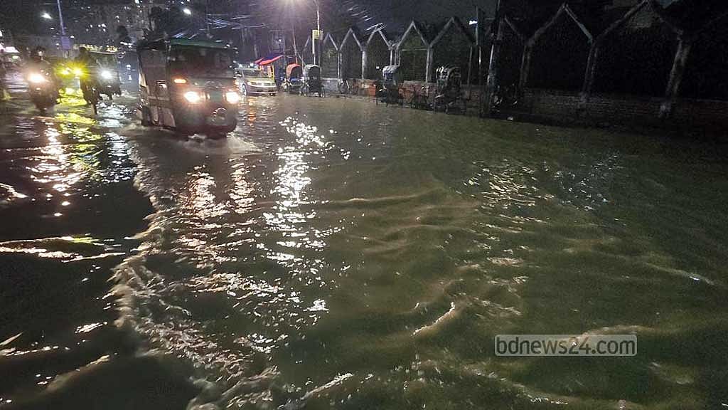 ওয়াসার মোড়ে জলাবদ্ধতা সড়কে চলছে যানবাহন।