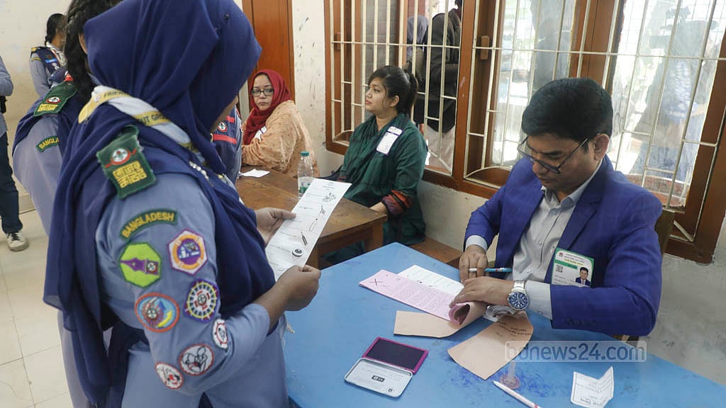 The Election Commission held a mock voting drill at Sher-e-Bangla Nagar Government Girls' High School in Dhaka on Nov 29. As part of the exercise, voters collect ballot papers from election officials. Photo: Abdullah Al Momin