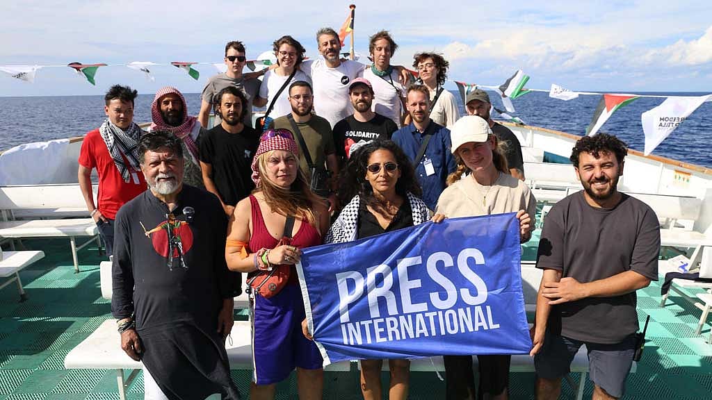 A picture showing Shahidul Alam alongside other members of the Freedom Flotilla. He wears a Punjabi with the art of Abu Sayed on it. The art on the Punjabi is the mirror image of the art on the black shirt in the allegedly AI-made picture.