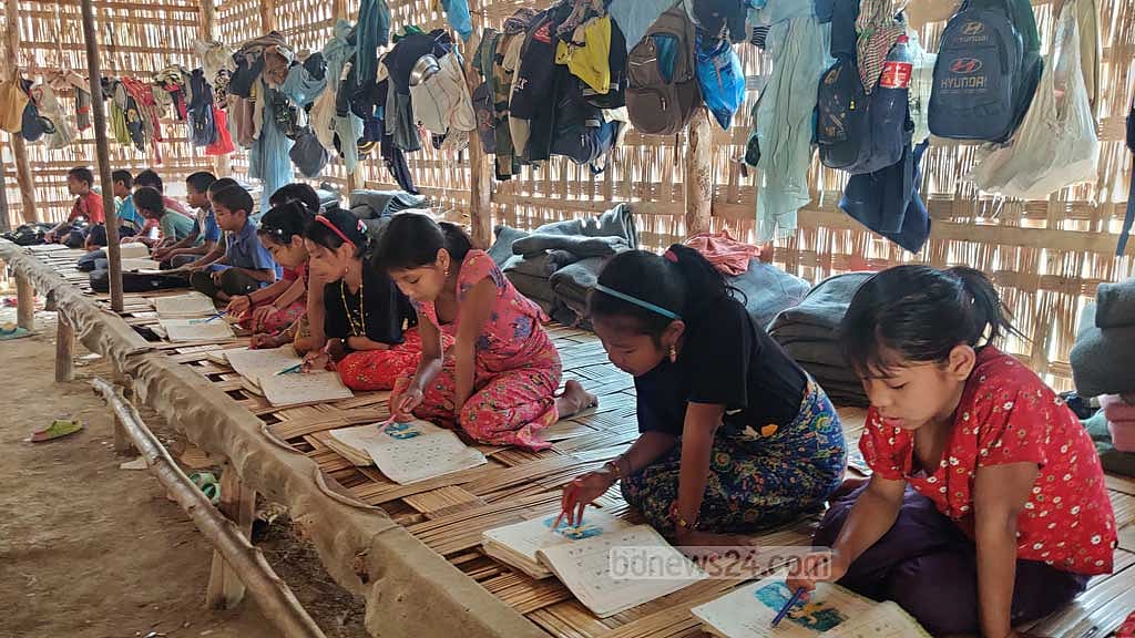 Hostel students studying on tarpaulins spread across the floor of a semi-concrete room