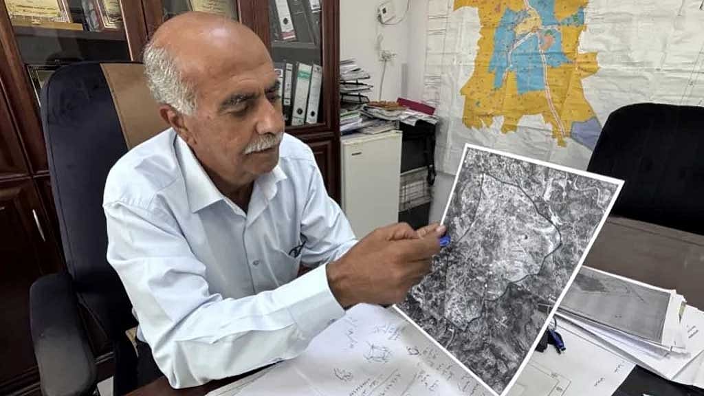 তায়বেহ ঘিরে কিভাবে সামরিক কার্যক্রম বাড়ছে ম্যাপে তা দেখাচ্ছেন শহরের মেয়র সুলাইমান খুরিয়েহ। ছবি: আল জাজিরা।   