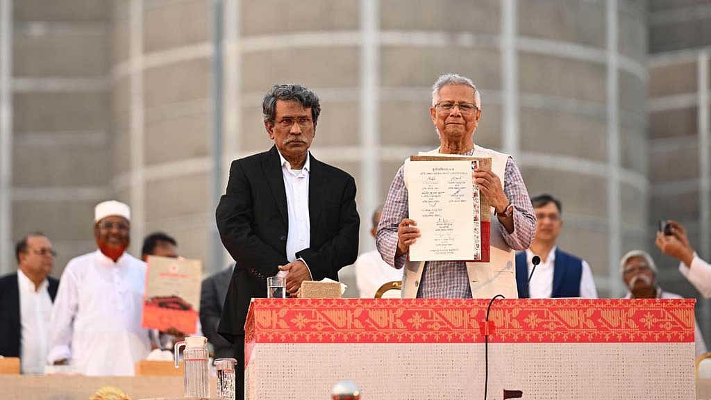 Chief Advisor Muhammad Yunus, accompanied by National Consensus Commission Vice-Chair Ali Riaz, holds up the July National Charter after signing it at the parliament’s South Plaza. File Photo