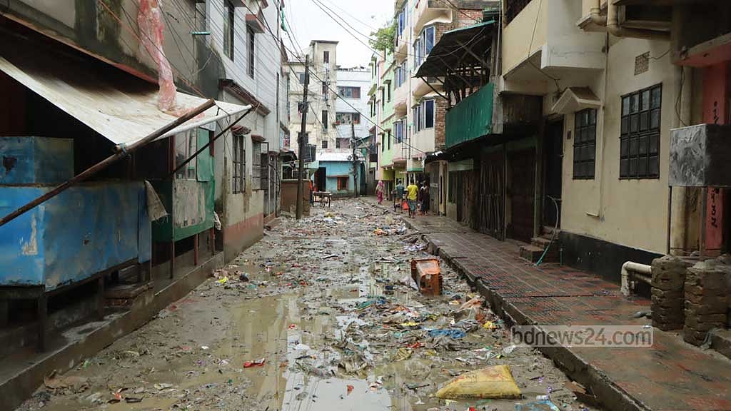 শহরে আর্মিপাড়া এলাকায় বন্যার পানি নামার পর কাদামাখা সড়ক।