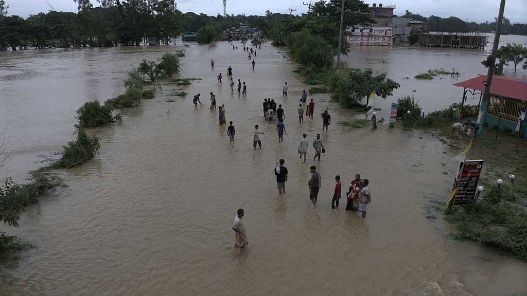 সাতকানিয়ার বাজালিয়া বুড়ির দোকান এলাকায় সড়কে জাল ফেলে মাছ ধরছে স্থানীয় লোকজন।