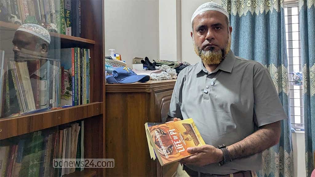 Minhaz Rahman holds the books of his son Mahtab Rahman, who died in the Milestone tragedy.