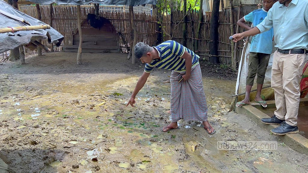 Jasim Uddin points to the spot in his yard where the bullet struck his son Huzaifa in the head.