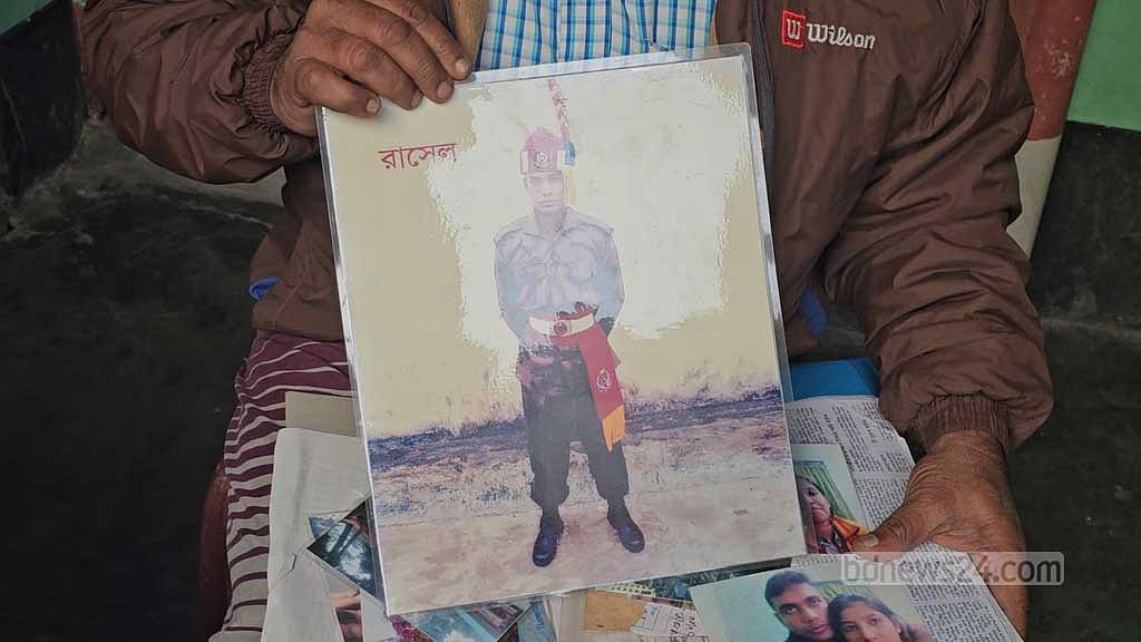 Family members showing a photograph of missing Rasel Gazi.