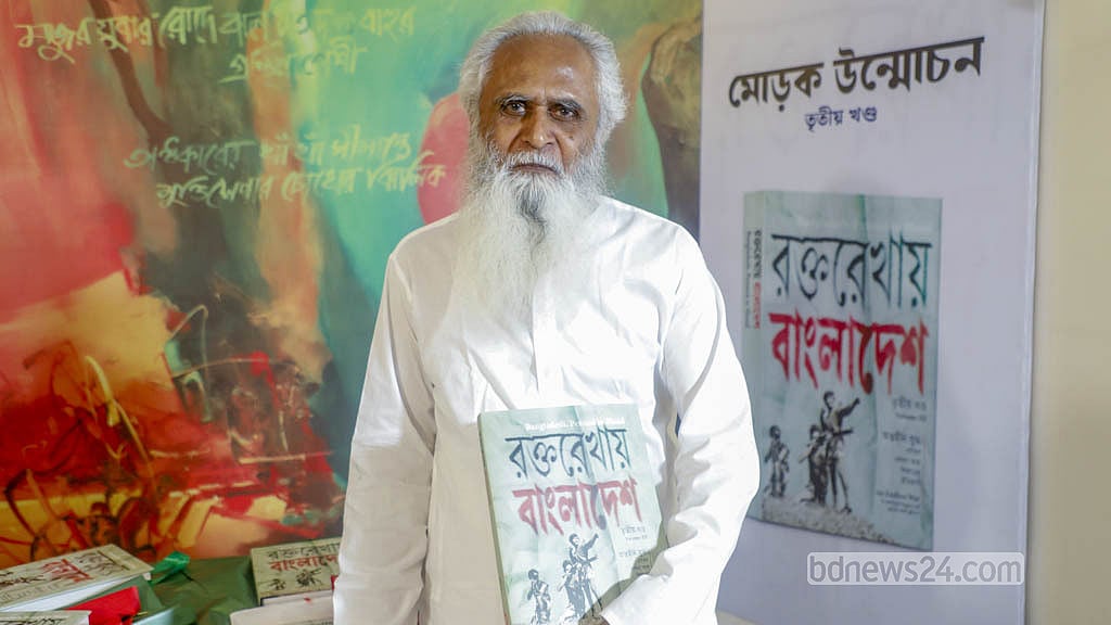 Freedom fighter Kamrul Aman holds a copy of “Bangladesh, Penned in Blood” at the unveiling ceremony.