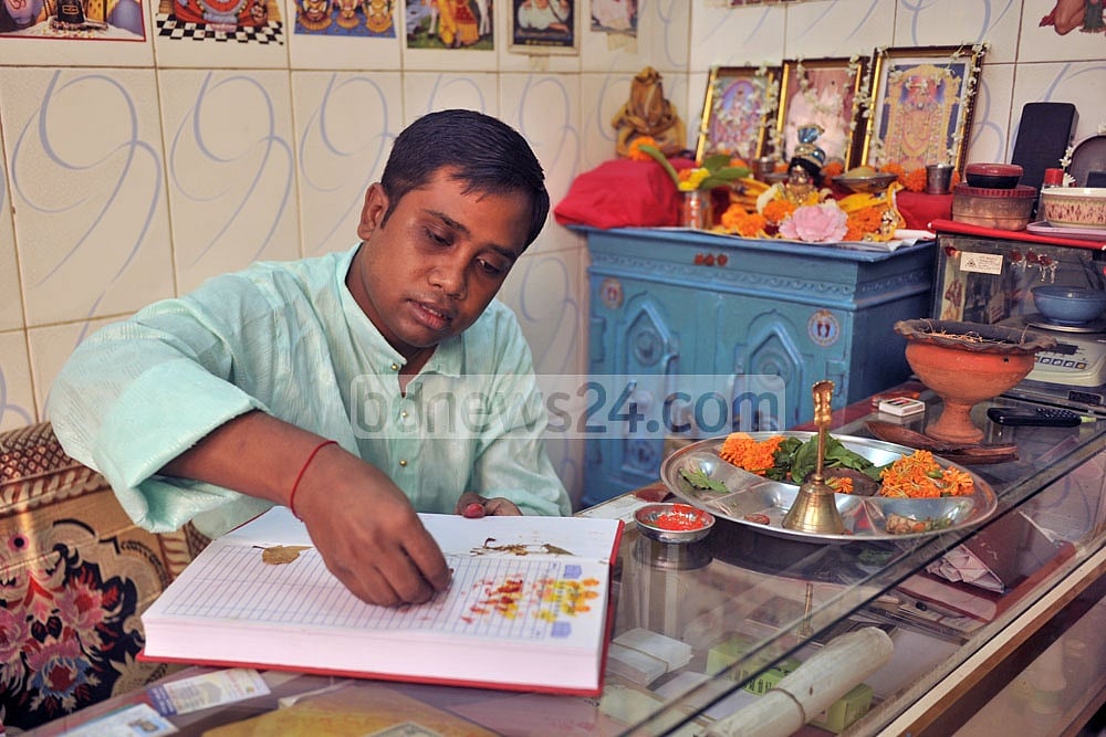 পুরনো পঞ্জিকা অনুযায়ী বছর শুরুর দিনে রাজধানীর তাঁতীবাজারে হালখাতা খুলছেন এক ব্যবসায়ী।  