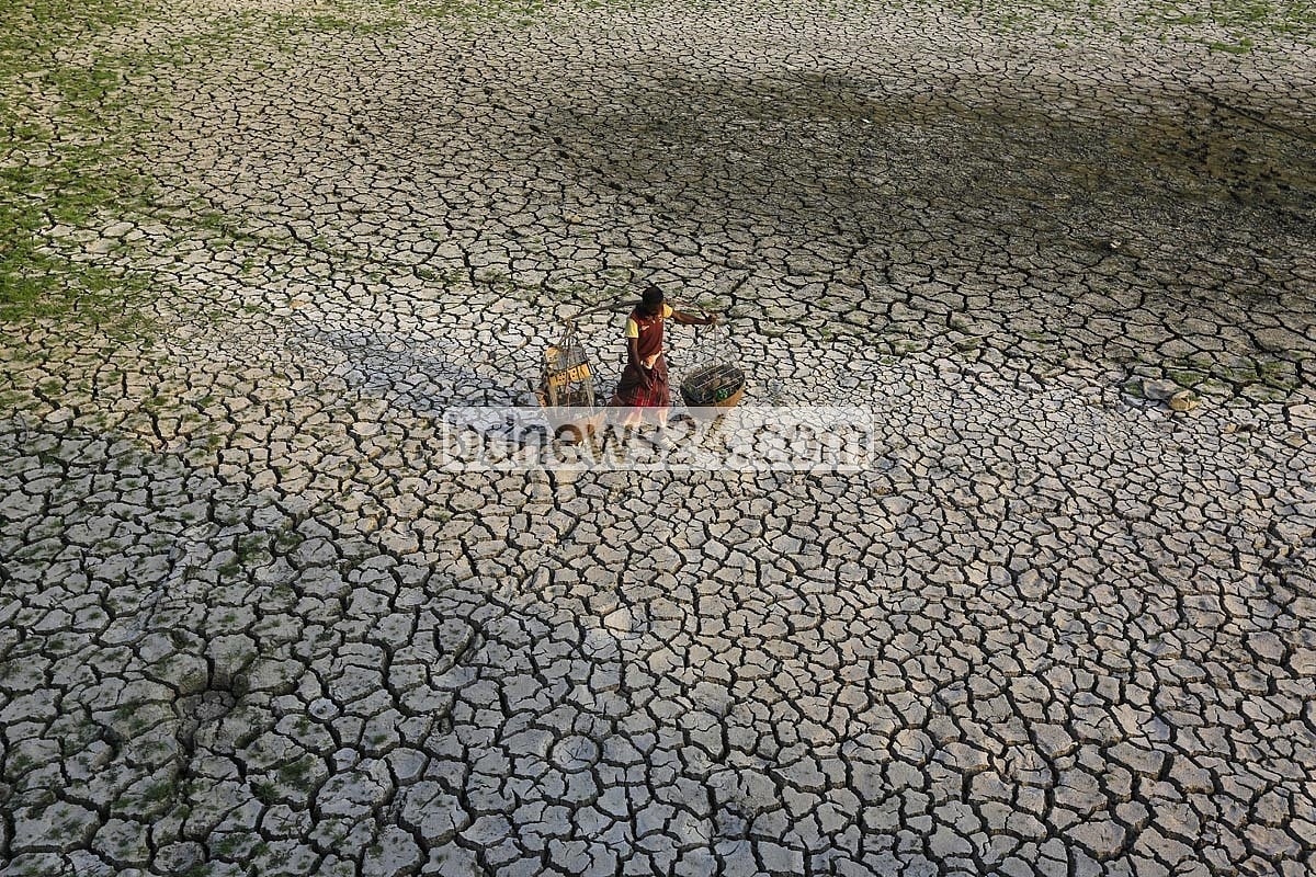 রাজধানী ঢাকাতেও ধারাবাহিক তাপমাত্রা বৃদ্ধি ঘটেছে। রাজধানী  বেরাইদ এলাকায় খরতাপে ফেটে চৌচির মাঠ দিয়ে যাচ্ছেন এক ফেরিওয়ালা  ছবি: মোস্তাফিজুর রহমান