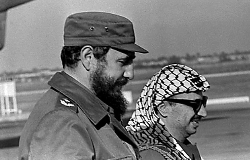 Fidel Castro (L) and PLO leader Yasser Arafat stand together at the airport in Havana during Arafat's first visit to Cuba November 14, 1974. Reuters 