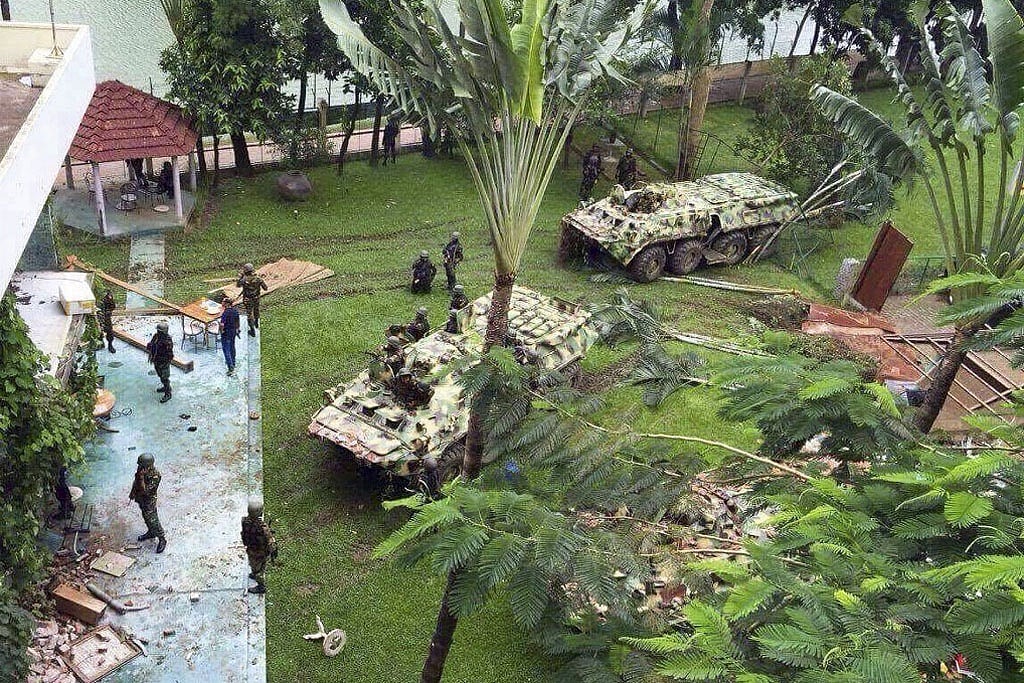 Armoured vehicles enter Holey Artisan's green lawn after tearing down one side of the restaurant's boundary wall. 
