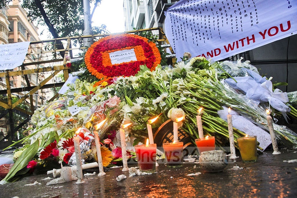 Mourners left flowers and candles near a police barricade, creating a makeshift memorial.  