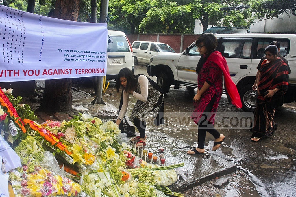 Mourners left flowers and candles near a police barricade, creating a makeshift memorial.  