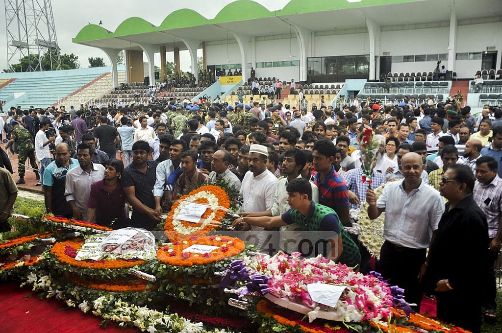 People pay tribute to victims in a public ceremony at Dhaka's Army Stadium.    