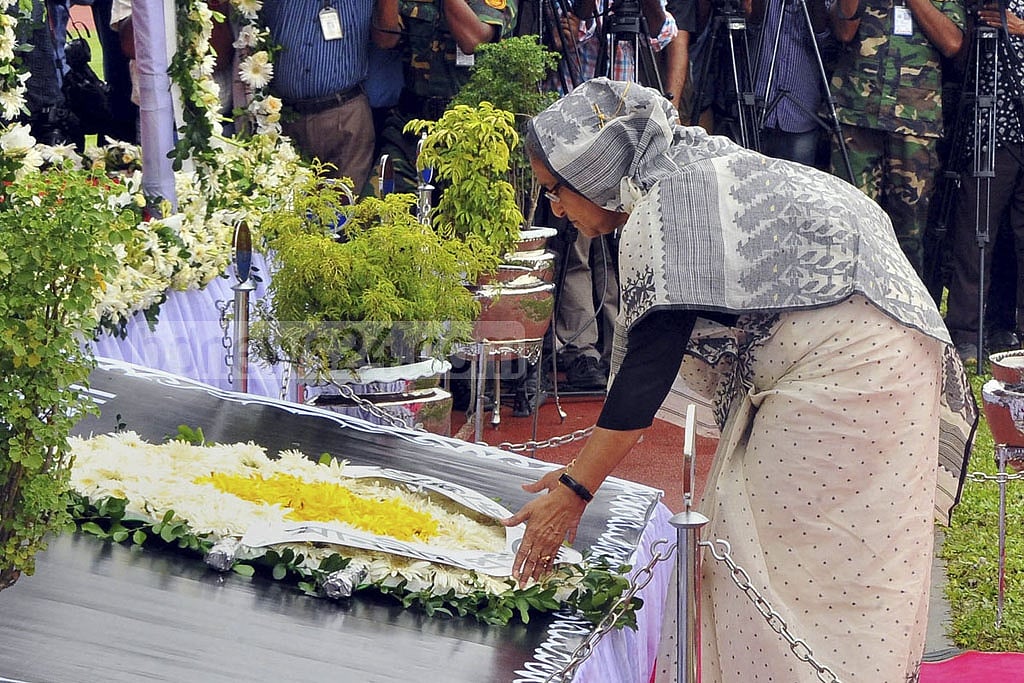 Prime Minister Sheikh Hasina places flowers before coffins of the three Bangladeshi victims at Dhaka's Army Stadium. 
