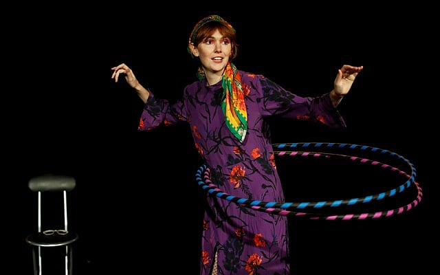 Comedian Elf Lyons hula hooping on stage before her performance in 