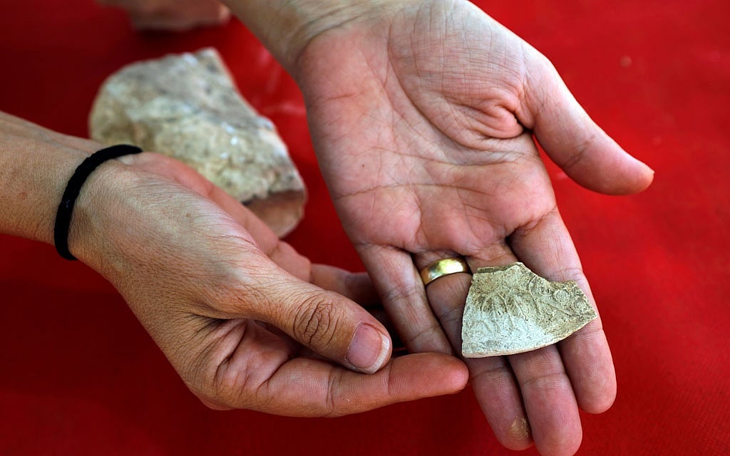 An archaeologist from the Israel Antiquities Authority shows off one of the findings discovered at the site where the remains of a mosque was uncovered and which the authority say is one of the world's oldest mosques, in the outskirts of the Bedouin town of Rahat in southern Israel July 18, 2019. Reuters 