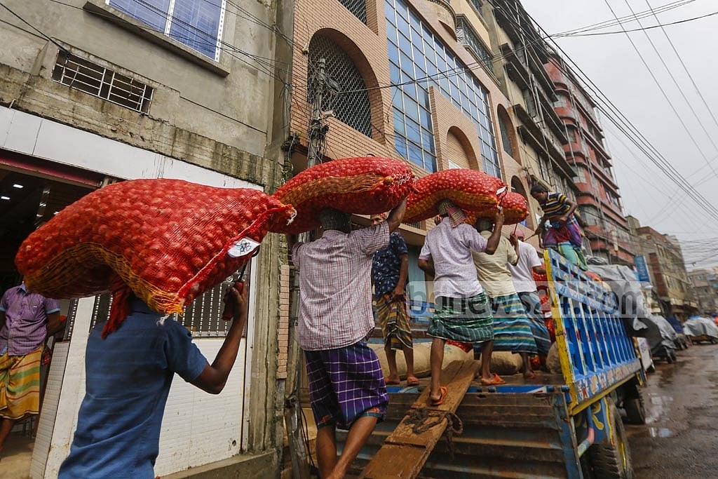 Workers are busy loading onion bags onto trucks to transport them to different markets from Shyambazar wholesale market in Dhaka. Photo: Mahmud Zaman Ovi 