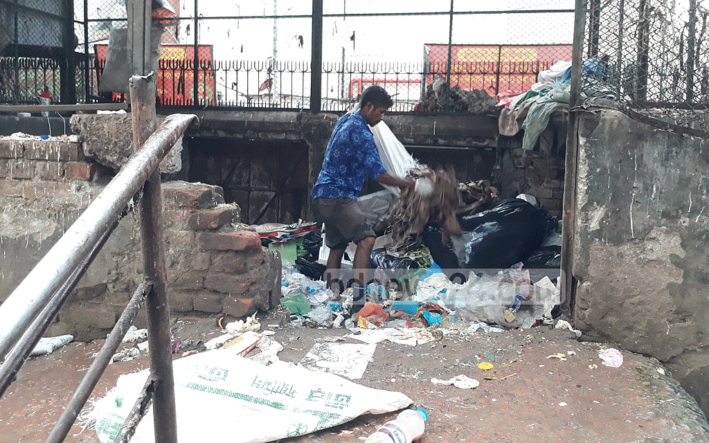 A cleaner at Bangabandhu Sheikh Mujib Medical University Hospital's waste disposal area is working without wearing any safety gear. A cleaner at Bangabandhu Sheikh Mujib Medical University Hospital's waste disposal area is working without wearing any safety gear.