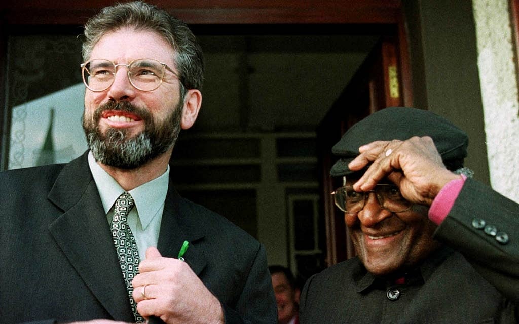 FILE PHOTO: Sinn Fein President Gerry Adams (L) smiles with South Africa's Archbishop Desmond Tutu October 1, after meeting at Sinn Fein's headquarters. Archbishop Tutu, the Nobel Peace Prize winner, was on a one day visit to Northern Ireland to promote peace. - REUTERS/Paul McErlane/File Photo 
