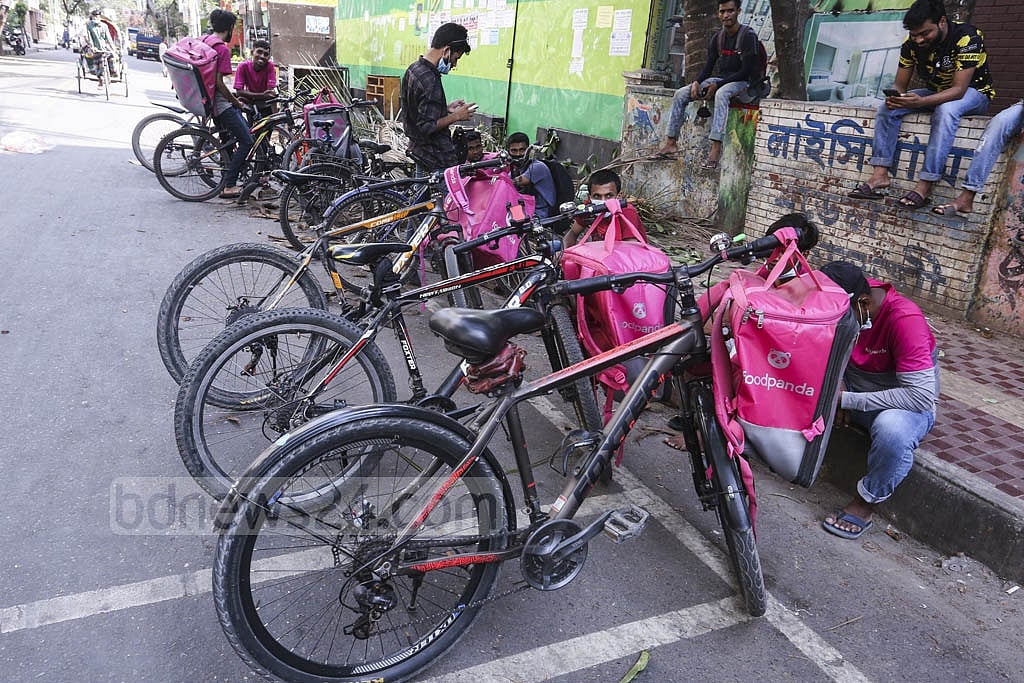 Apr 20, 2021: Online food delivery service staff wait in front of a restaurant at Mirpur 2, amid the strict lockdown imposed in a bid to curb the spread of the coronavirus. The expansion of the e-commerce in Bangladesh was a highlight of 2021 but the sector was marred by allegations of fraud as the year rolled on. Photo: Asif Mahmud Ove Apr 20, 2021: Online food delivery service staff wait in front of a restaurant at Mirpur 2, amid the strict lockdown imposed in a bid to curb the spread of the coronavirus. The expansion of the e-commerce in Bangladesh was a highlight of 2021 but the sector was marred by allegations of fraud as the year rolled on. Photo: Asif Mahmud Ove