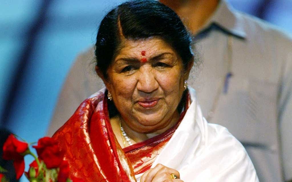 Bollywood playback singer Lata Mangeshkar looks at a bouquet she received on her 75th birthday during a celebration in Mumbai on Sept 28, 2003. REUTERS/FILE PHOTO 