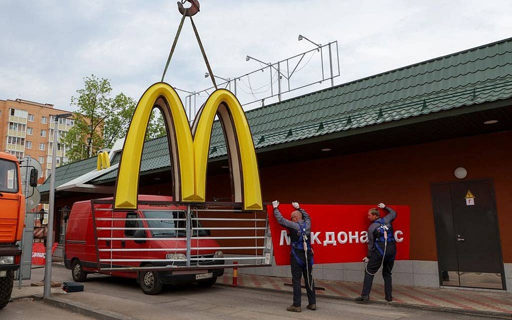 Workers use a crane to dismantle the McDonald's Golden Arches while removing the logo signage from a drive-through restaurant of McDonald's in the town of Kingisepp in the Leningrad region, Russia June 8, 2022. REUTERS 